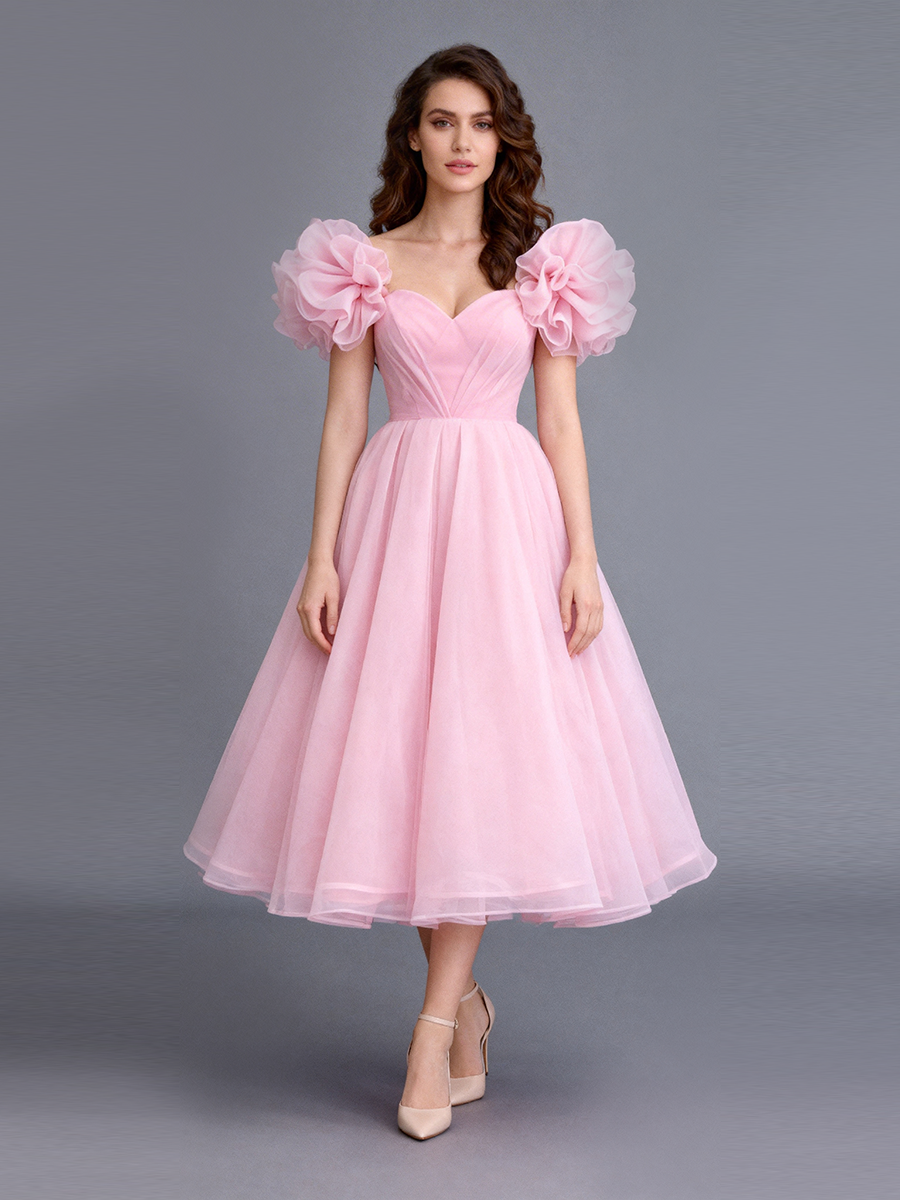 Full front view of a model wearing a blush tulle A-line evening dress with puff sleeves and a sweetheart neckline.