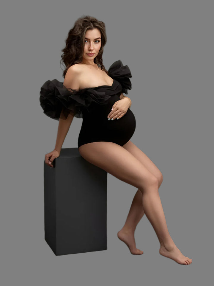 Woman in a black outfit posing on a dark background