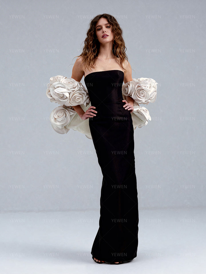 Full front view of a model wearing a black elegant evening dress with a detachable 3D white floral cape for wedding party.