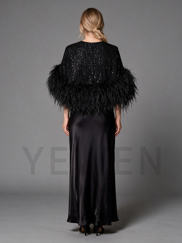 Back view of a black feather trim evening gown, showing the flowing satin maxi skirt.
