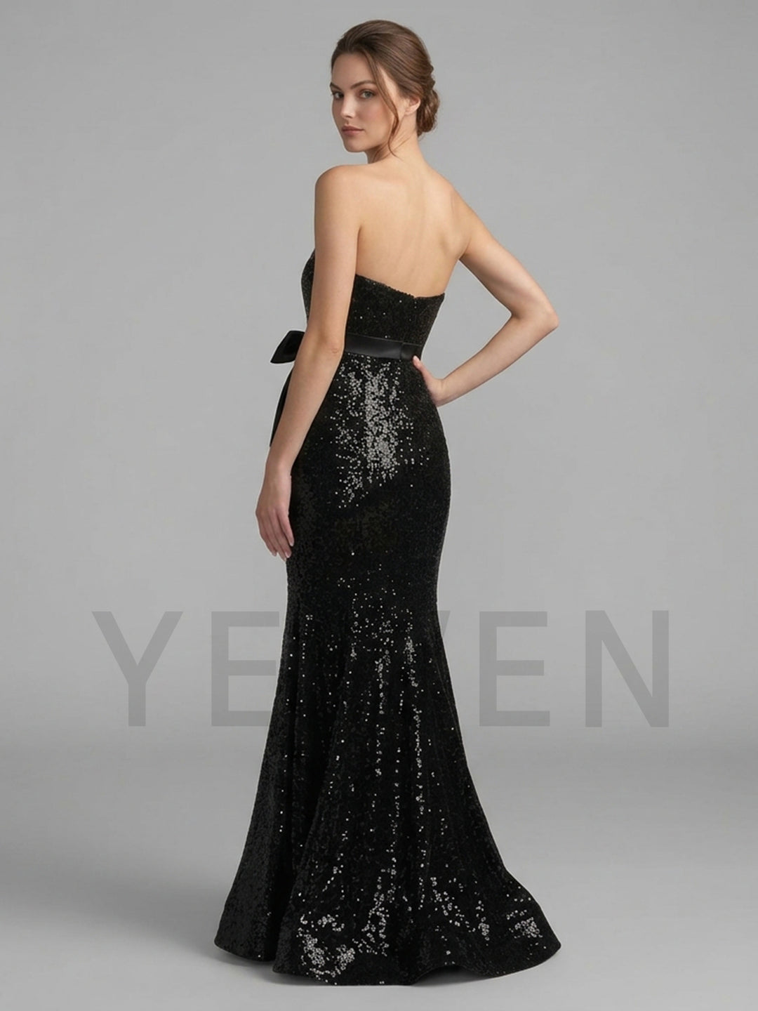 Back view of a black sequin mermaid evening gown, showing the strapless design.