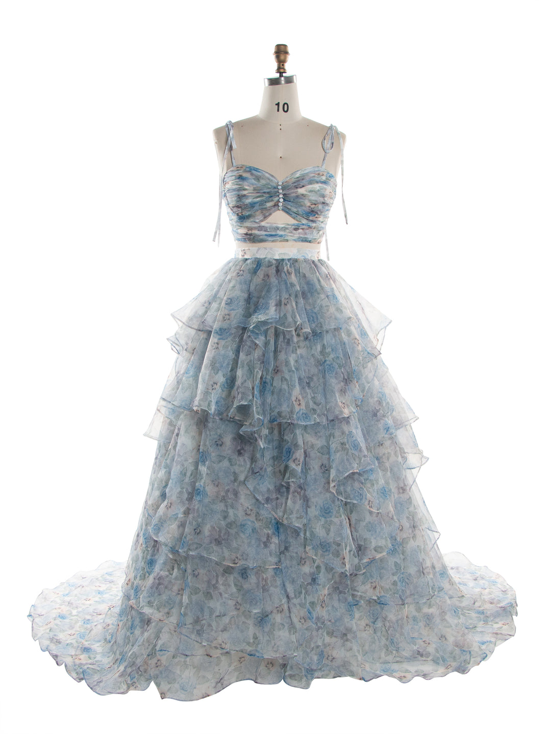A light blue and white floral tiered organza formal gown displayed on a dress form mannequin against a plain white background.