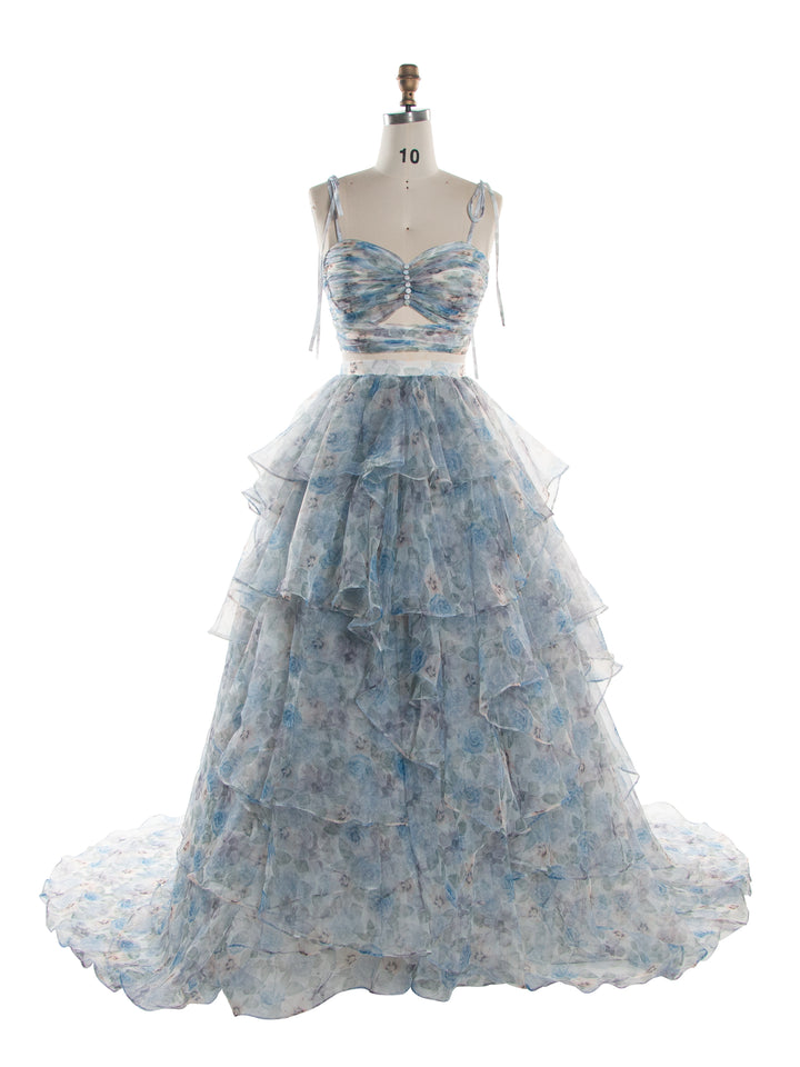 A light blue and white floral tiered organza formal gown displayed on a dress form mannequin against a plain white background.