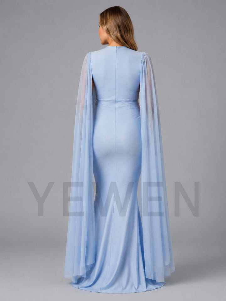 A woman shown from the back wearing a light blue floor-length gown with a fitted bodice, high neckline, and sheer draped cape sleeves, photographed against a plain gray studio background.