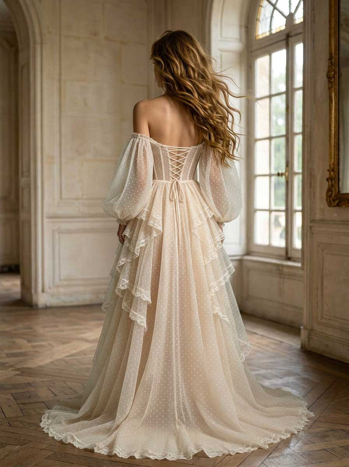 Back view of a model wearing a boho fairycore evening gown with a lace-up corset back and layered tulle skirt.