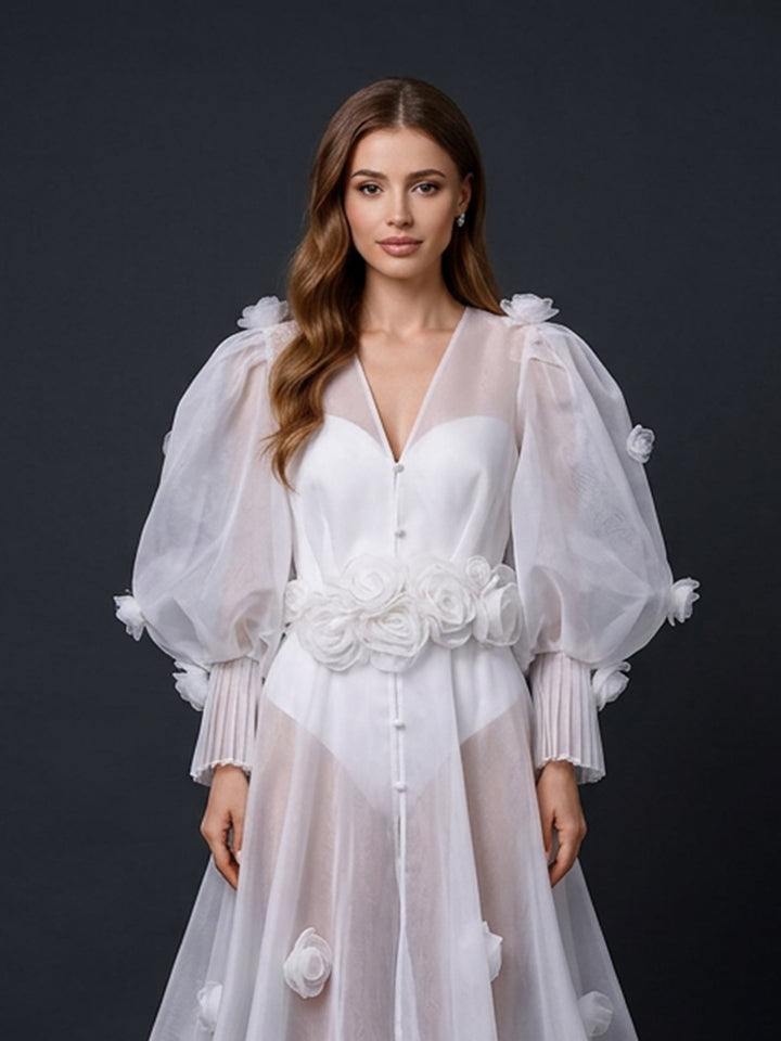 Close-up view of a stunning white transparent long-sleeve bridal robe with delicate floral appliques and a flattering belted waist.