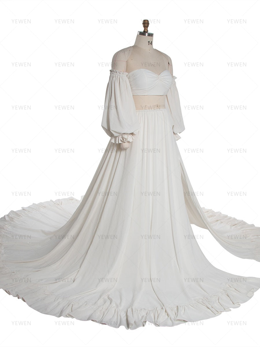 An off-the-shoulder white two-piece costume set displayed on a mannequin, featuring a strapless sweetheart crop top with long balloon sleeves and a matching high-waisted pleated skirt with a long train.