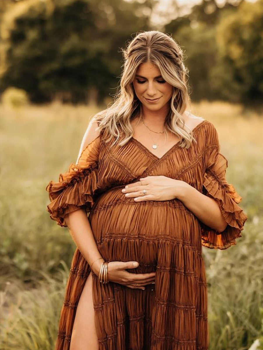Pregnant woman in a brown dress standing in a field