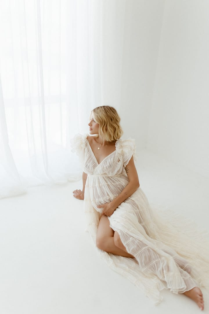Woman wearing chiffon dress for photo shoot in studio setting with side slit maxi elegant styling