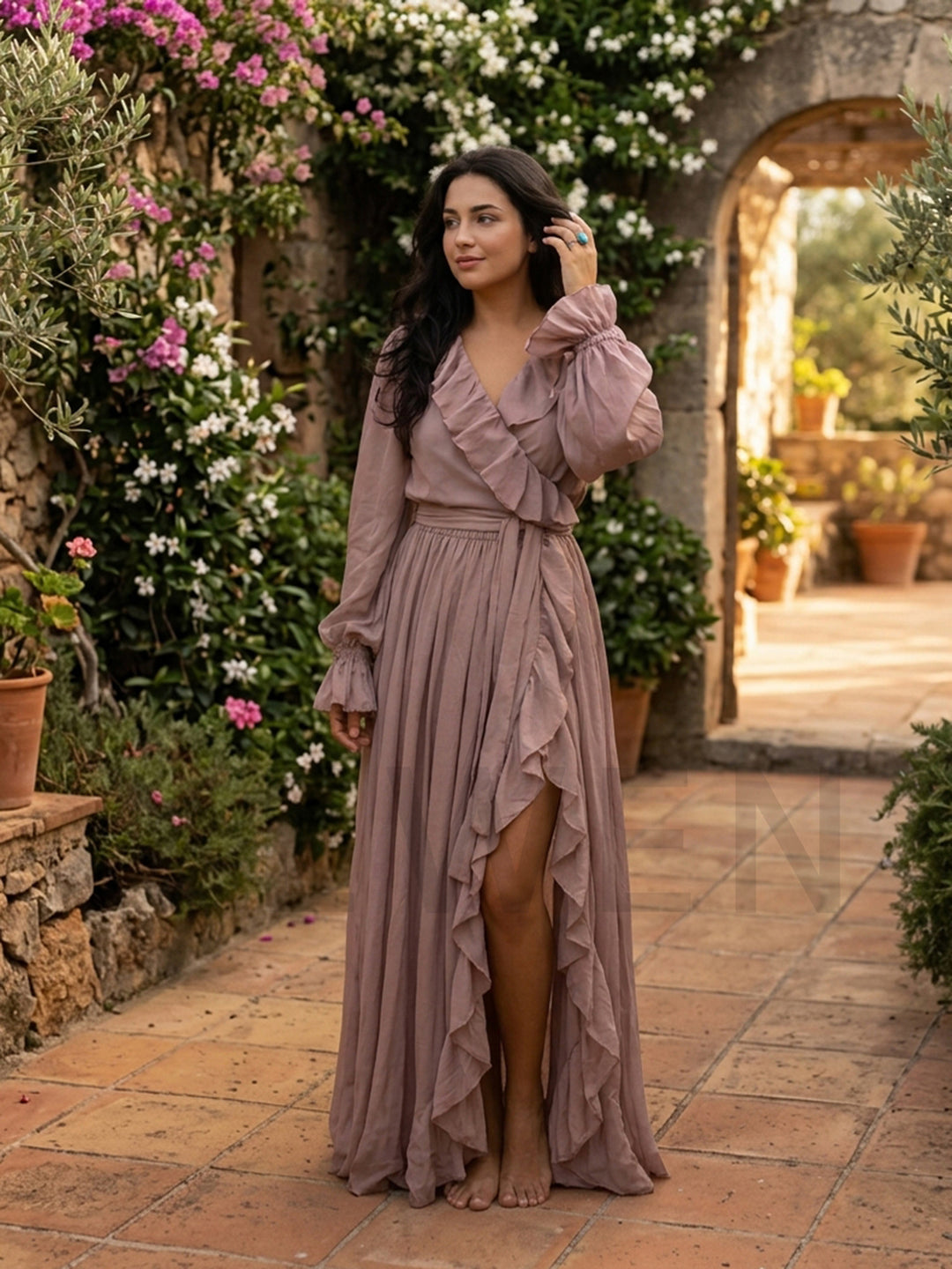 Woman wearing a dusty rose cotton linen maxi dress in an outdoor garden setting.