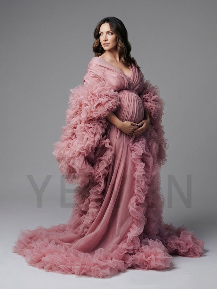 Side profile of a dusty pink tulle maternity gown with ruffle sleeves and a flowing skirt.