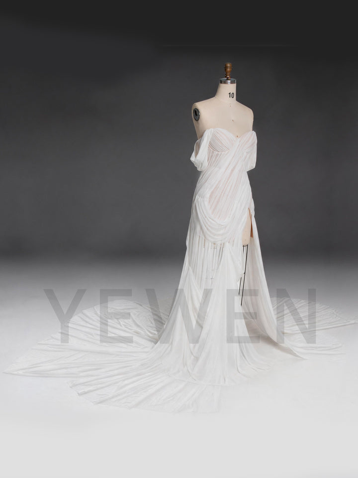 Side profile of a white chiffon bridal gown with a corset bodice and draped neckline.