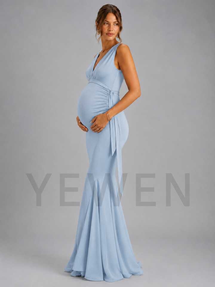 A pregnant model wearing a light blue sleeveless maternity gown with a deep V-neckline, gathered waist, and flared skirt, standing against a solid gray studio background. A large semi-transparent 'YEWEN' brand watermark is visible across the lower half of the image.