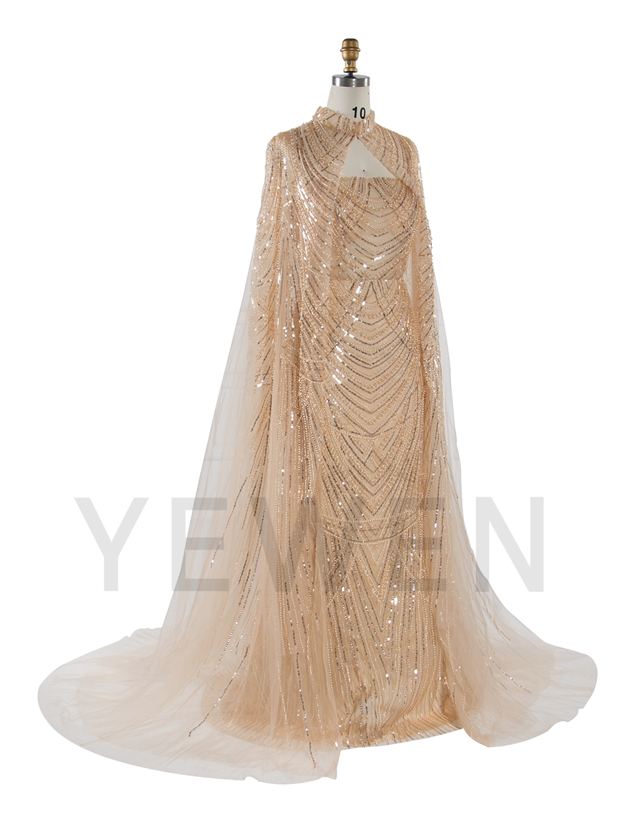 Side view of hand-beaded evening dress with cape showing elegant silhouette and flowing formal design