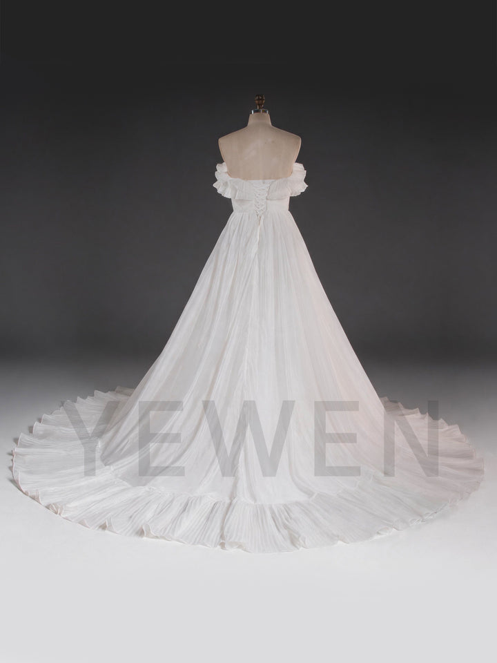 Back view of a white flowing wedding dress, showing the lace-up back closure.