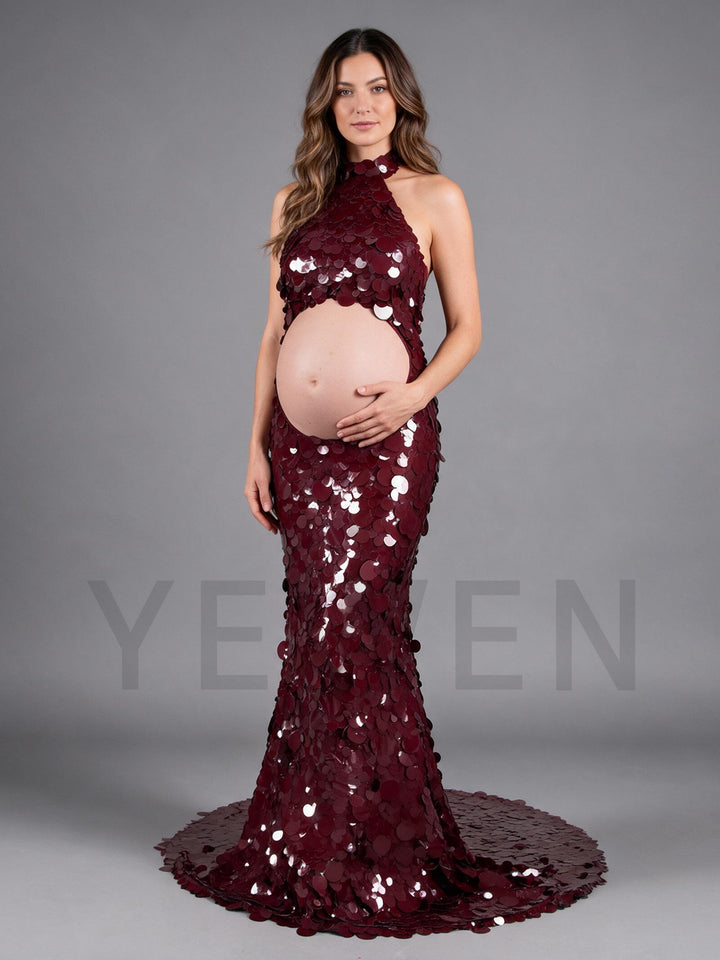 Side view of a burgundy sequin maternity gown with a cutout belly and halter neck.