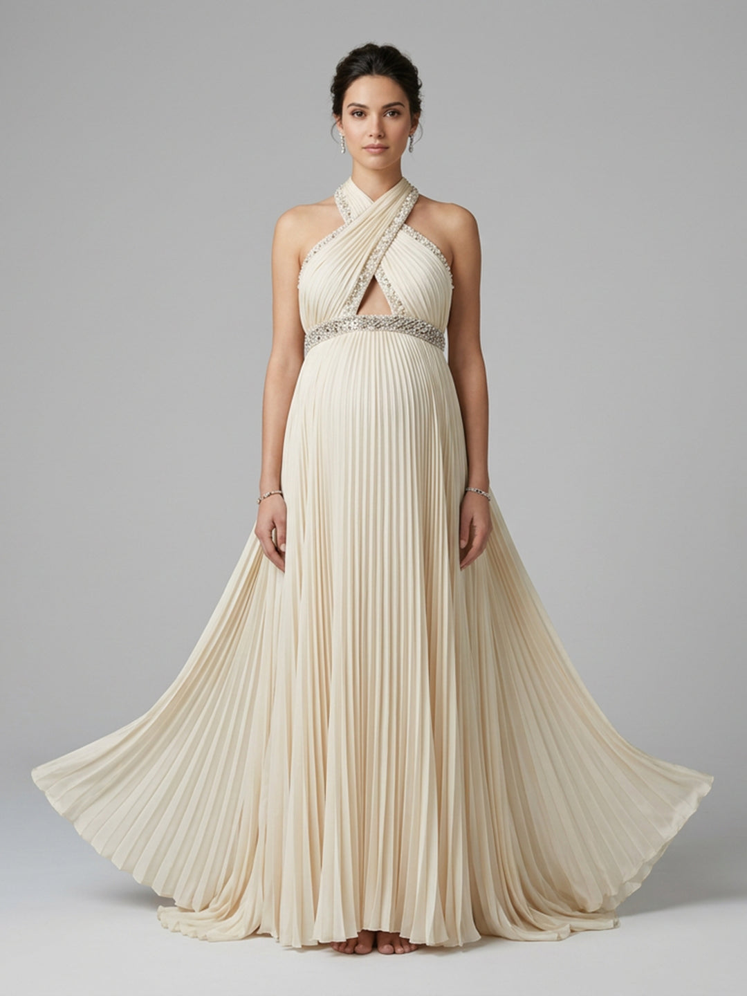 Full front view of a pregnant model wearing an elegant halter neck maternity baby shower dress with a flowing pleated skirt.