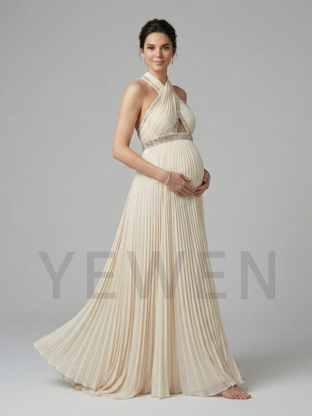 Side view of a pregnant model wearing a stunning halter neck maternity baby shower dress with a soft pleated chiffon skirt.