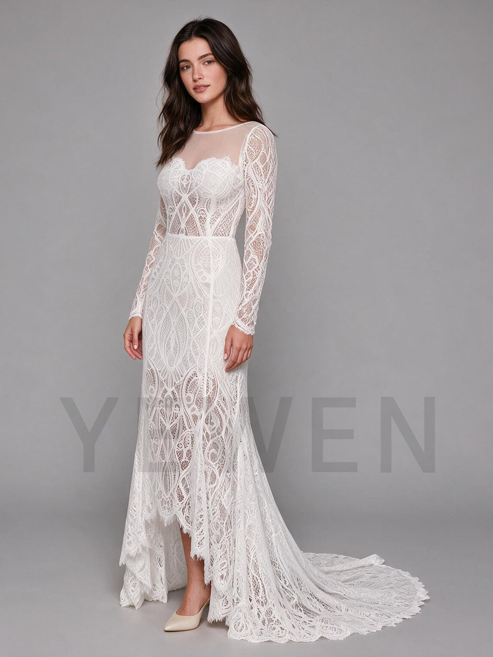 Side profile of an ivory full lace boho wedding dress featuring a high-low hem and long sleeves.