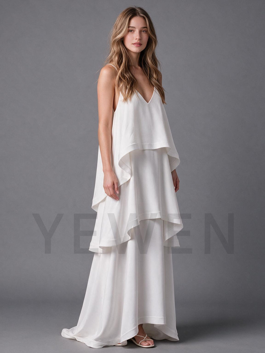 Side profile of an ivory flowy boho wedding dress with tiered ruffle layers.