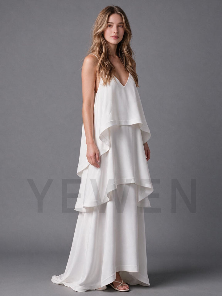 Side profile of an ivory flowy boho wedding dress with tiered ruffle layers.