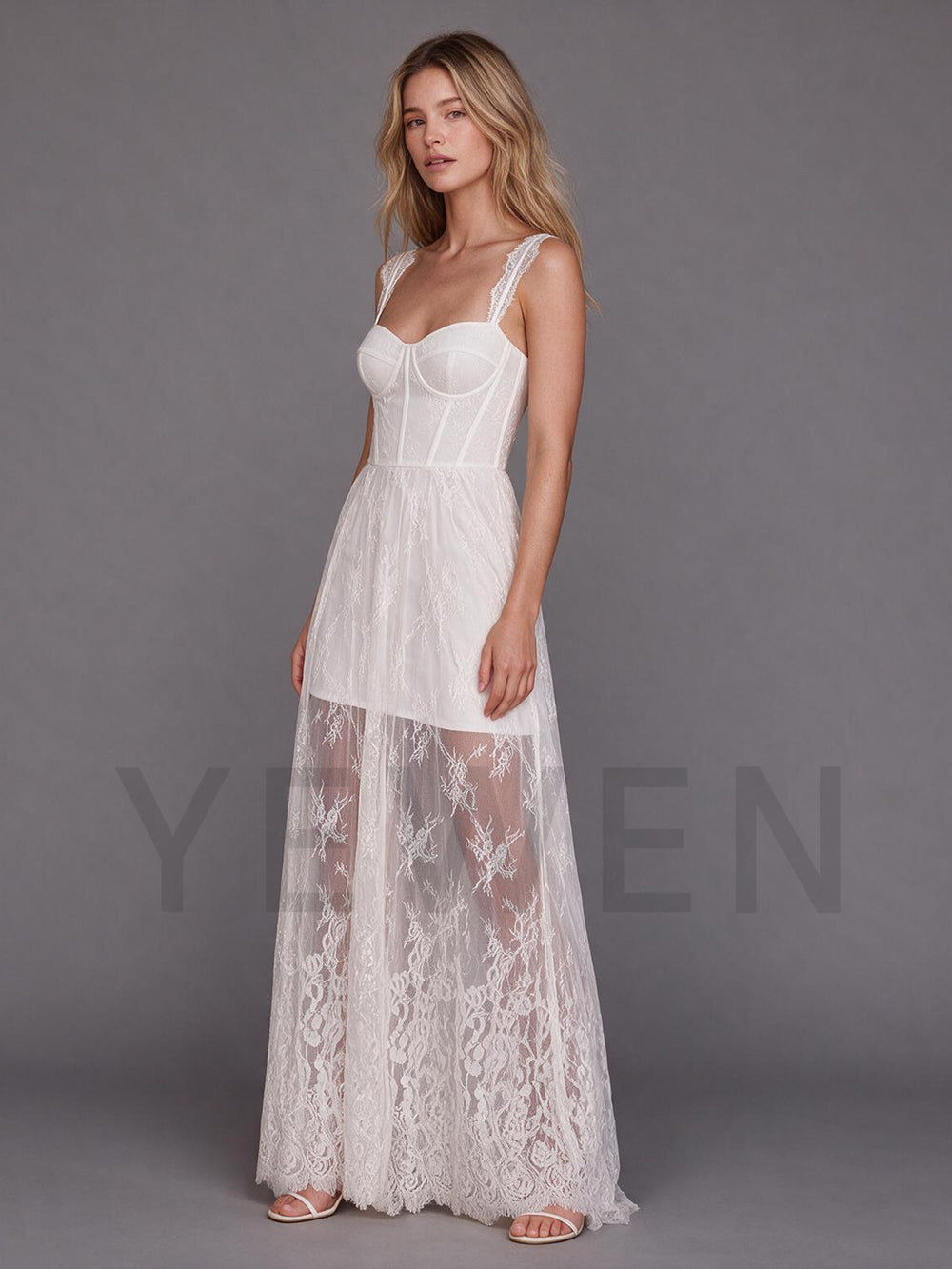 Side profile of an ivory lace boho wedding dress featuring a sheer flowing maxi skirt.