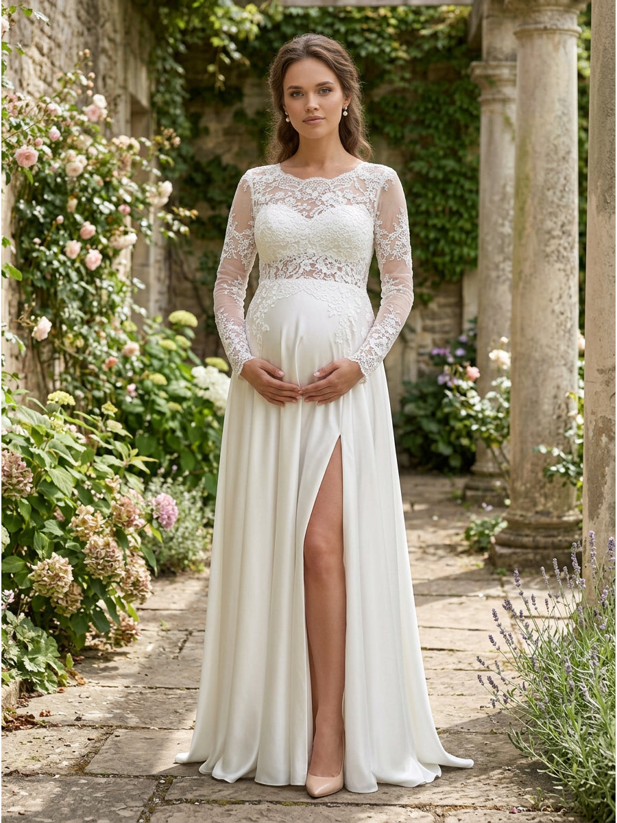 A pregnant woman wearing a long-sleeve ivory wedding dress with a lace bodice, empire waist, and high front slit, standing in a garden courtyard with stone columns and flowers.