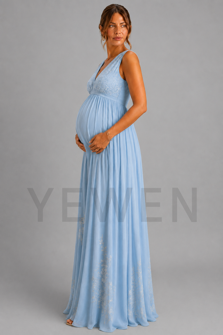 A pregnant woman modeling a light blue sleeveless maxi maternity gown with a lace bodice and flowing chiffon skirt, standing against a solid gray studio background.
