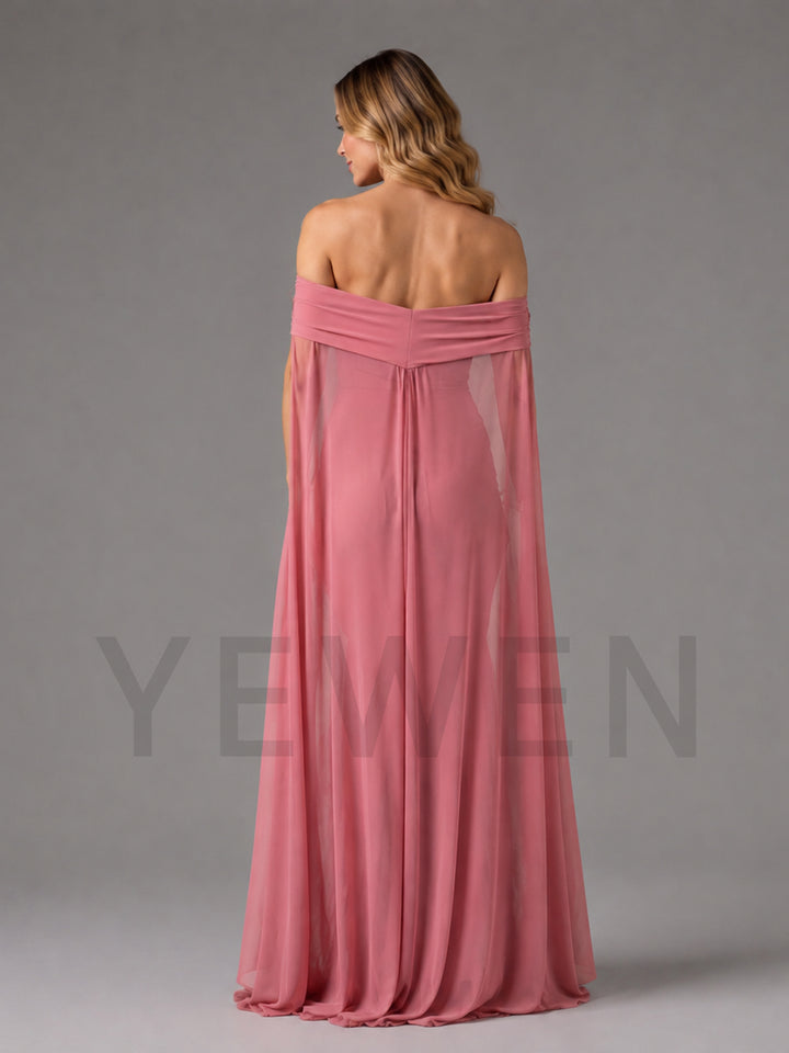 A woman modeling a floor-length dusty pink off-the-shoulder gown from the back, featuring a draped sheer overlay and a gathered waist, set against a solid gray studio background.