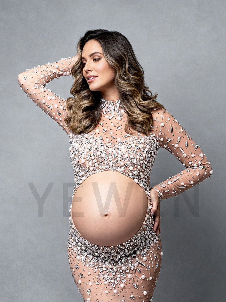 Pregnant woman wearing sexy beaded maternity dress with split design in professional studio photoshoot