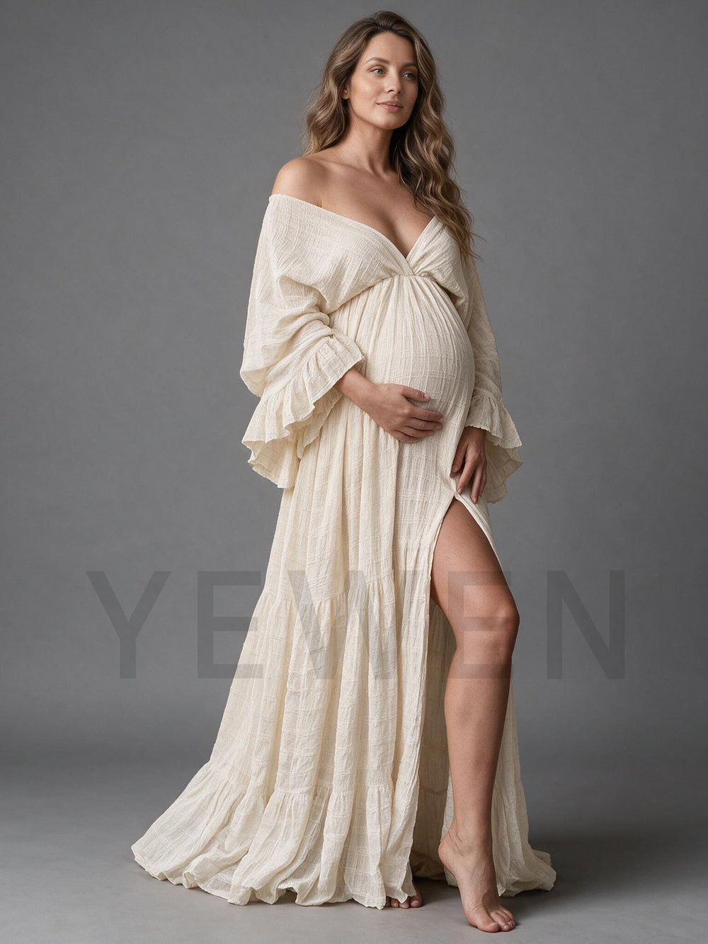 Side view of a cream cotton linen maternity photoshoot gown with a high side slit.
