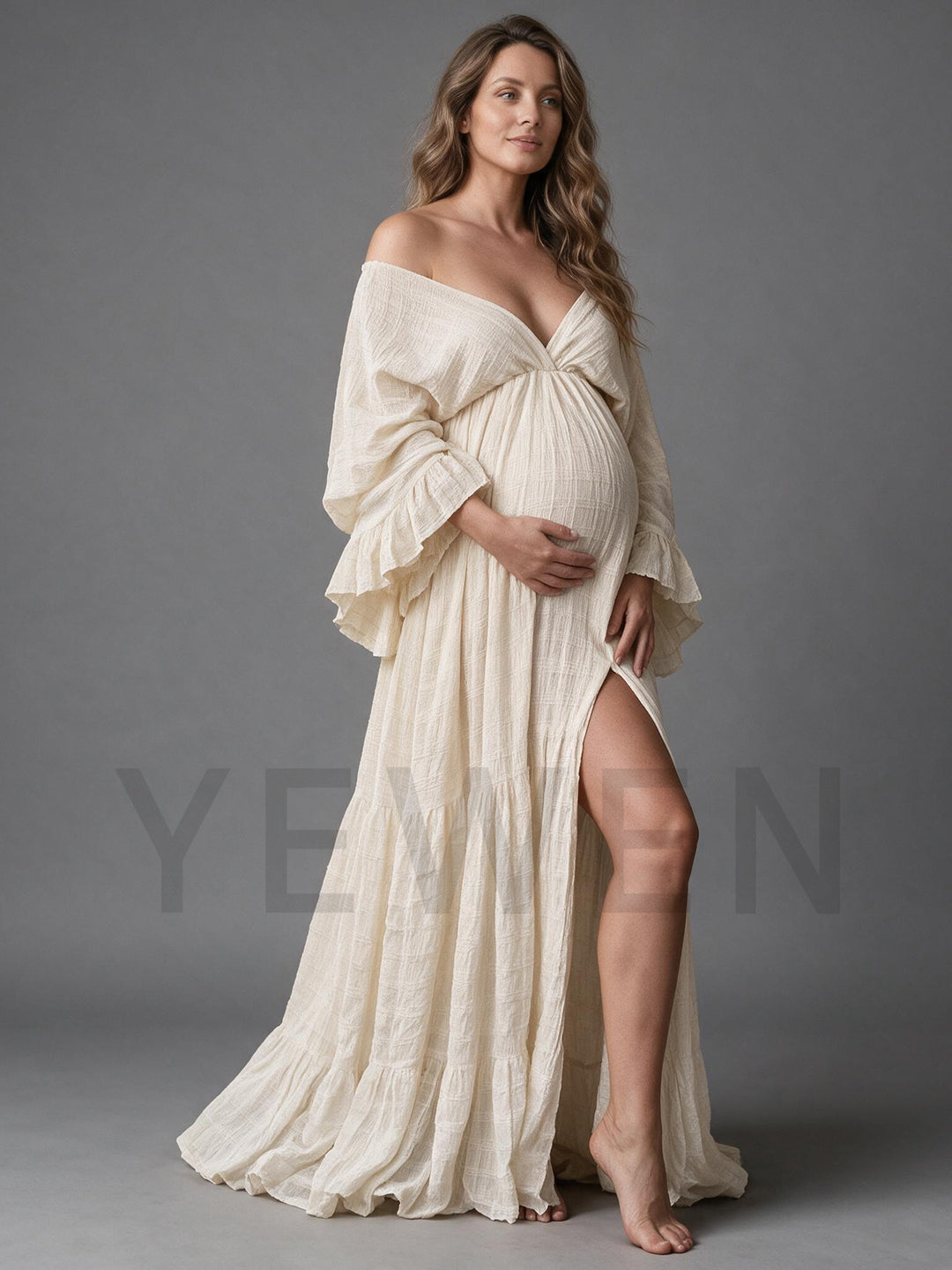 Side view of a cream cotton linen maternity photoshoot gown with a high side slit.