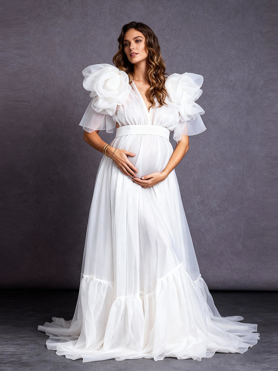 Full front view of a pregnant model wearing a maternity wedding dress with a V-neckline and organza flower sleeves.