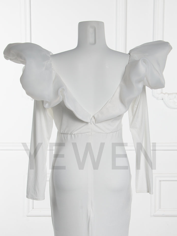Close-up back view of a maternity wedding gown highlighting the ruffle sleeve and bow details on a mannequin.