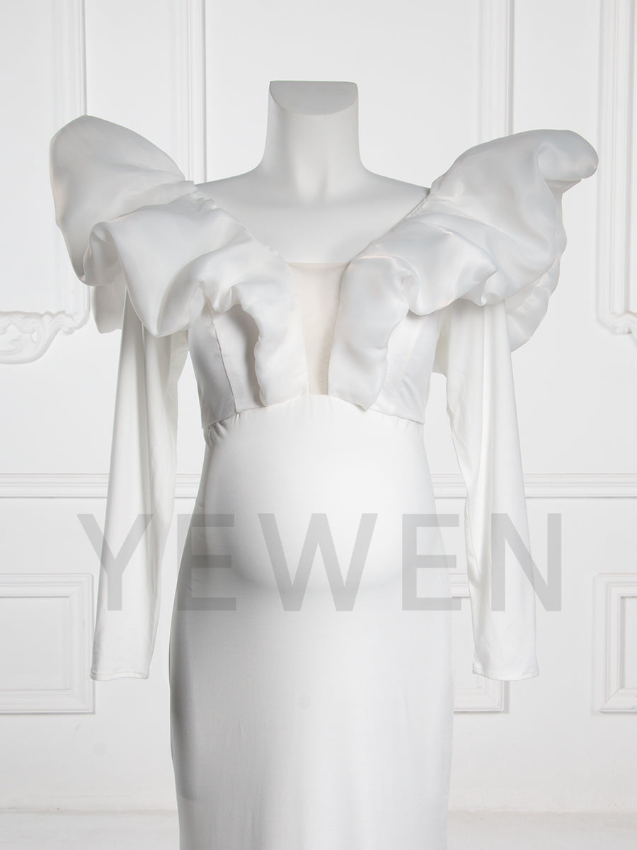 Close-up front view of a maternity wedding gown highlighting the V-neckline and bow shoulder details on a mannequin.