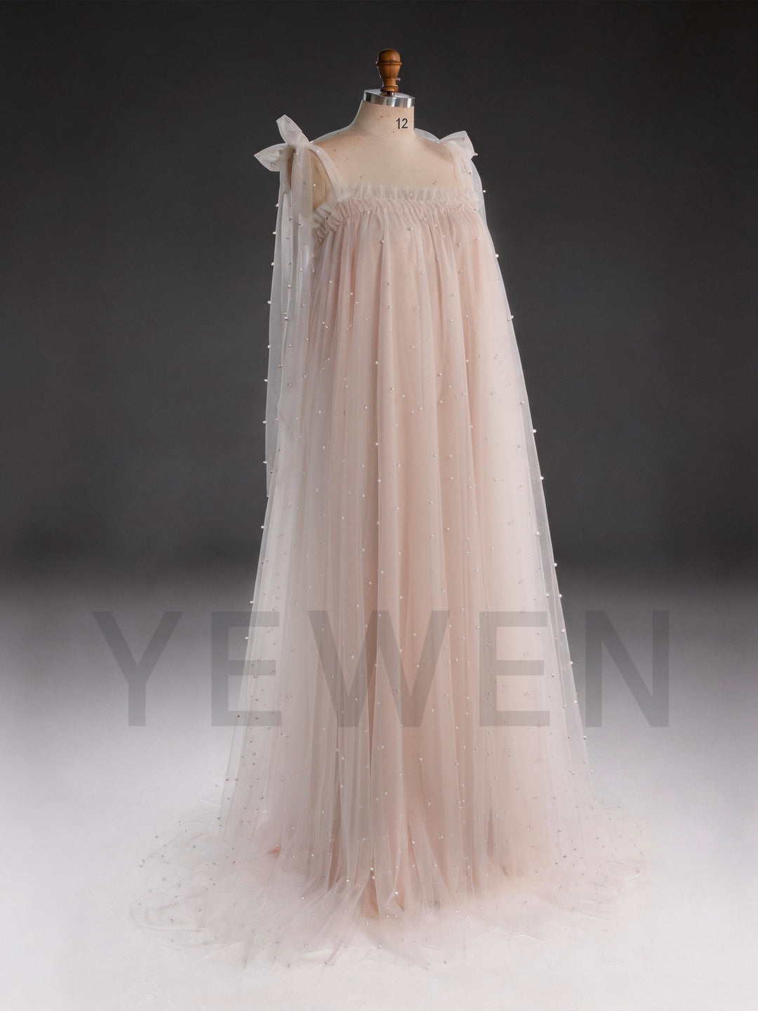 Side-back view of a blush pink sheer tulle dress for women with pearl embellishments.