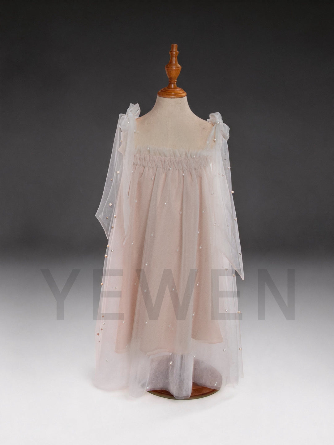Front view of a blush pink sheer cape pearl tulle dress for girls.