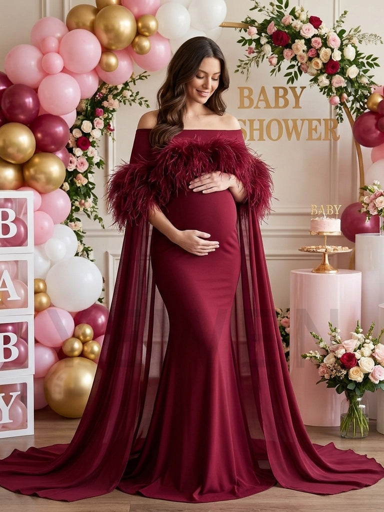 Burgundy off-shoulder feather cape pregnancy dress in a baby shower party setting.