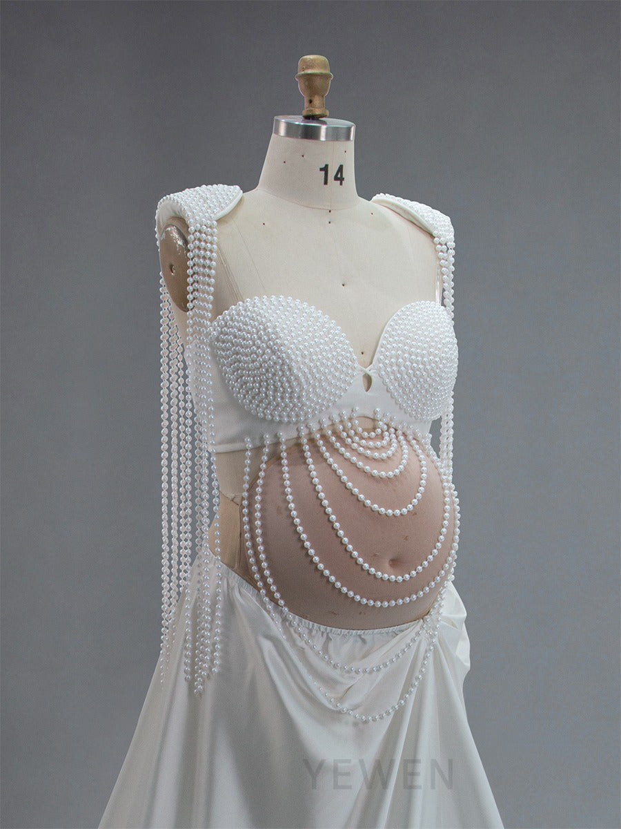 Elegant maternity photoshoot dress with pearl design in soft romantic lighting