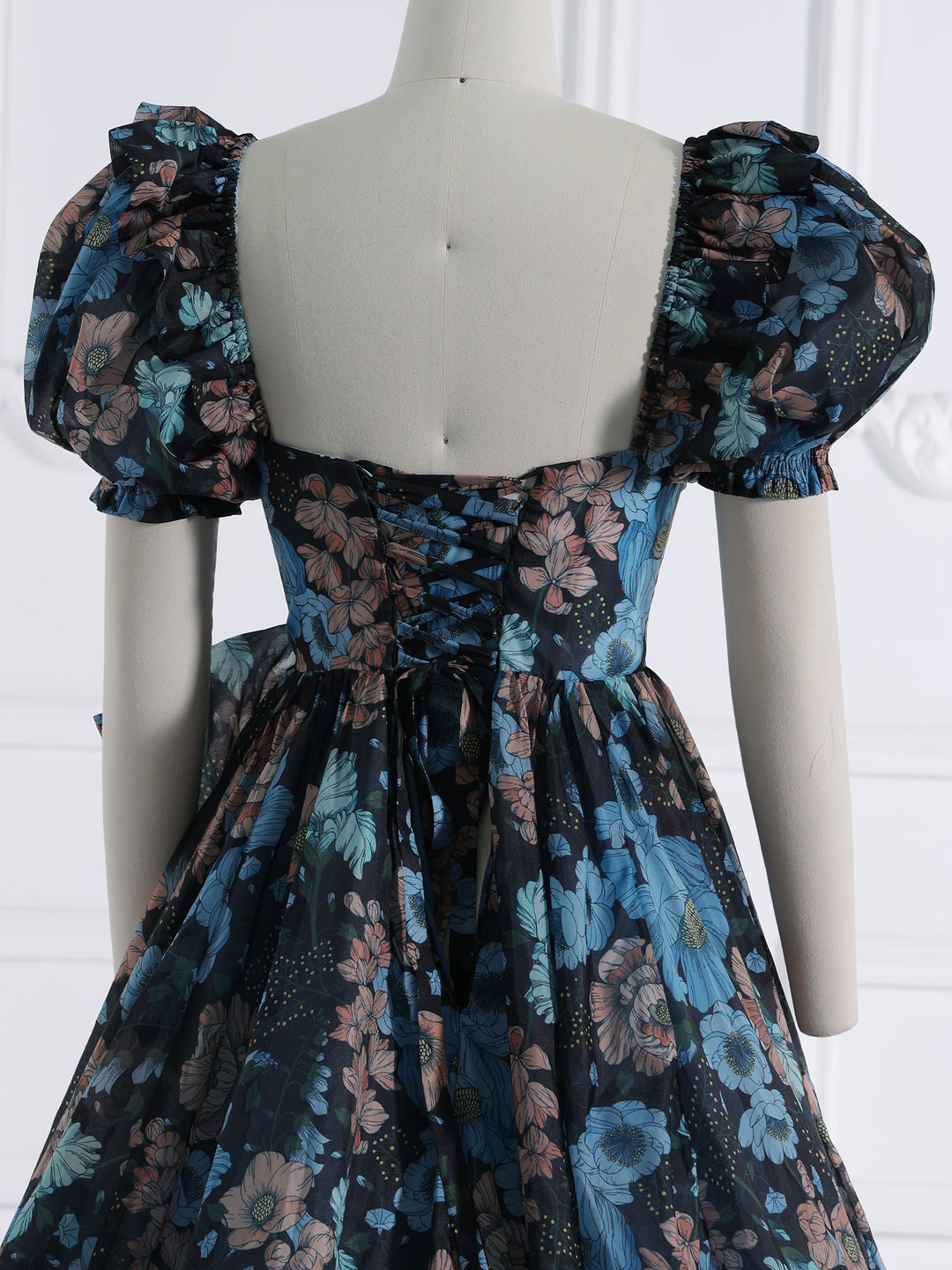 Close-up back detail of photoshoot dress highlighting flowing train and elegant organza craftsmanship