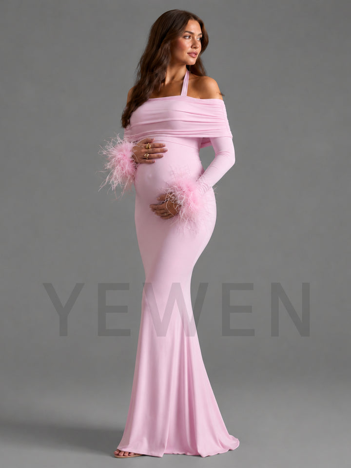 A pregnant model wearing a light pink off-the-shoulder maternity gown with long sleeves and fluffy feather accents on the cuffs, posed against a solid gray studio background. A large semi-transparent 'YEWEN' watermark is visible across the lower half of the image.