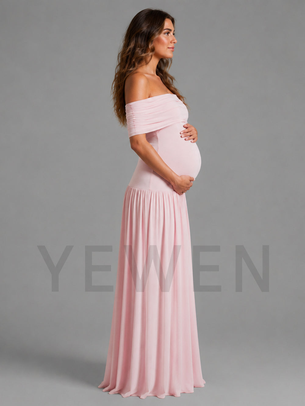 A pregnant woman stands in profile wearing a light pink off-the-shoulder maternity gown with a ruched bodice and flowing skirt, photographed against a plain gray studio background. A large translucent YEWEN watermark overlays the lower portion of the image.