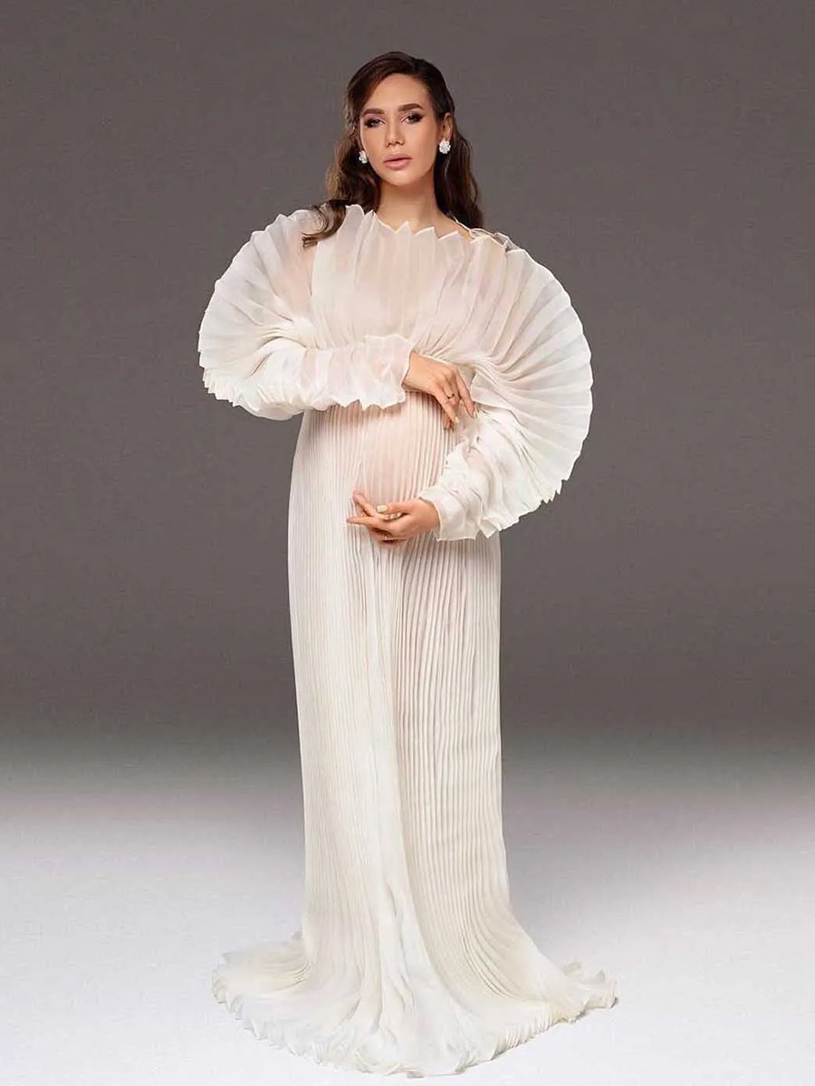Woman in a white pleated dress against a gray background