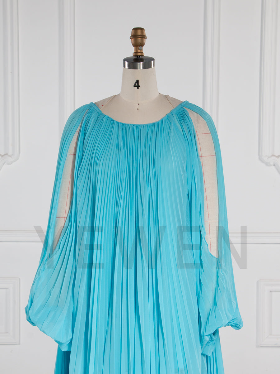 Close-up of pleated fabric detail on blue maternity photoshoot dress showing elegant texture and craftsmanship