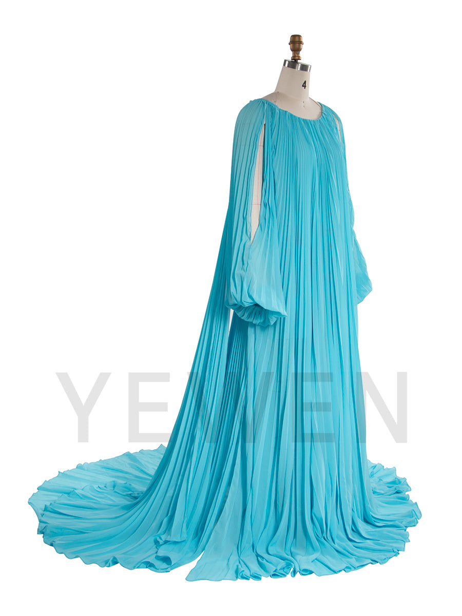 Side view of pleated maternity photoshoot dress showing long train and elegant flowing blue fabric movement