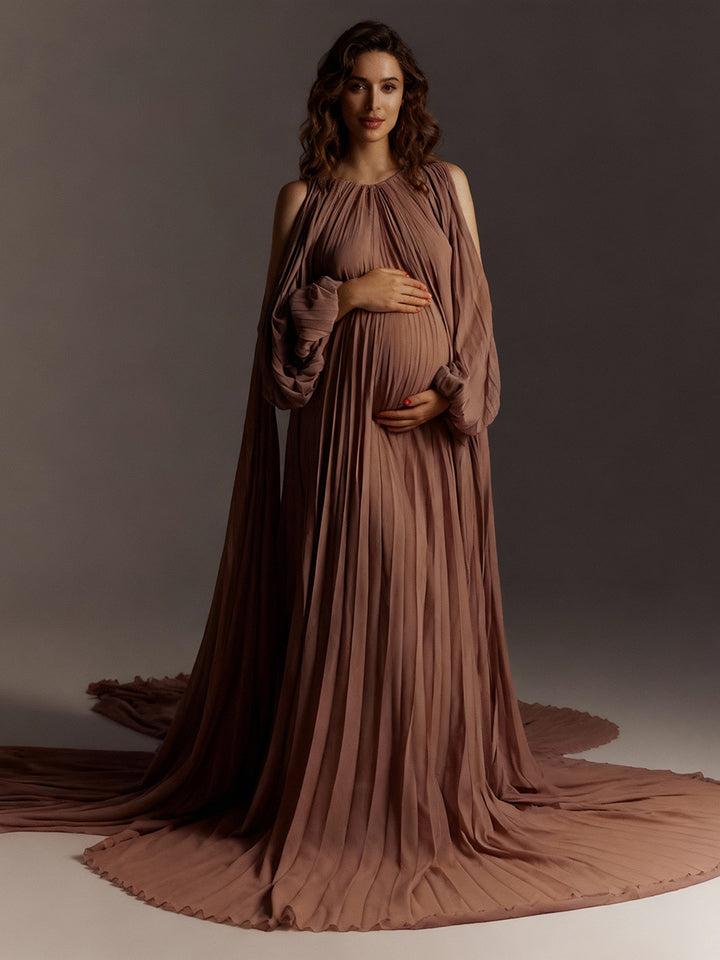 Elegant pleated brown maternity photoshoot dress styled in soft light for romantic pregnancy photography