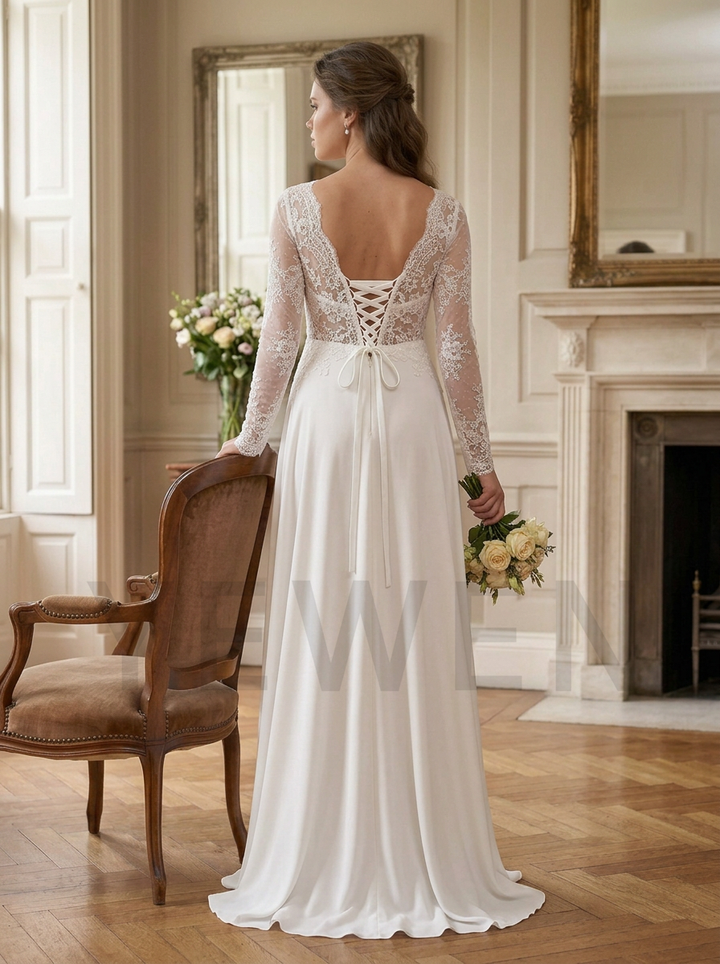 A woman stands in a bright room wearing a long white wedding dress from the back, showing a lace lace-up open back and sheer long sleeves. She holds a bouquet of flowers beside a wooden chair and fireplace.