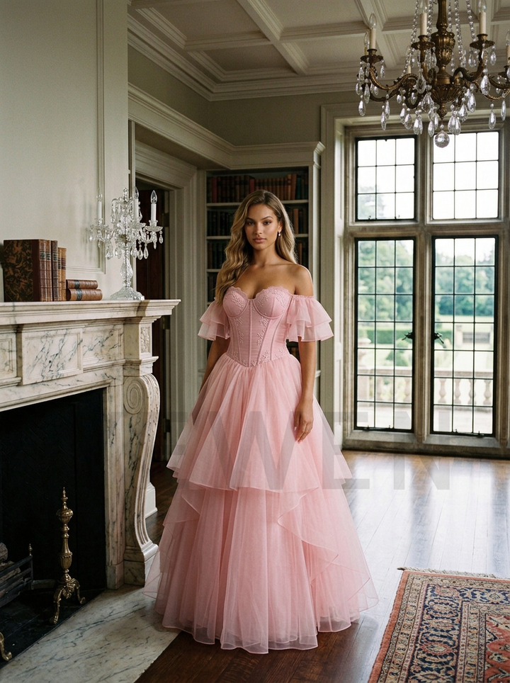 A woman wearing a light pink off-the-shoulder tulle ball gown stands in a grand, elegant room with a fireplace, large windows, and a chandelier.