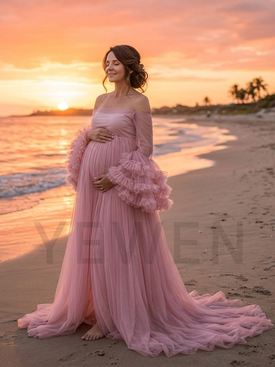 Light pink tulle maternity photoshoot gown worn on a sunset beach.