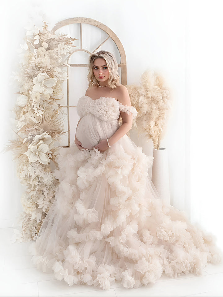 Pregnant woman wearing tulle photoshoot dress with cloud ruffles in professional studio maternity photography